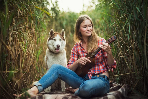 Young caucasian woman playing ukulele