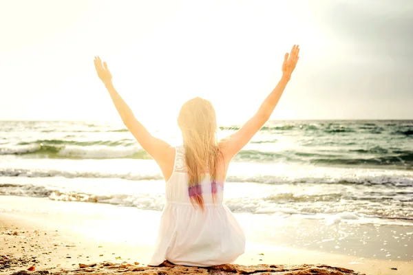 Young beautiful caucasian female enjoying the sun on beach during sunrise or sunset