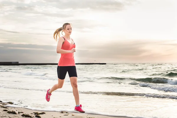 Fitness sport model  doing exercises during outdoor work out on sunrise. Beautiful caucasian female training outside on seaside in the morning