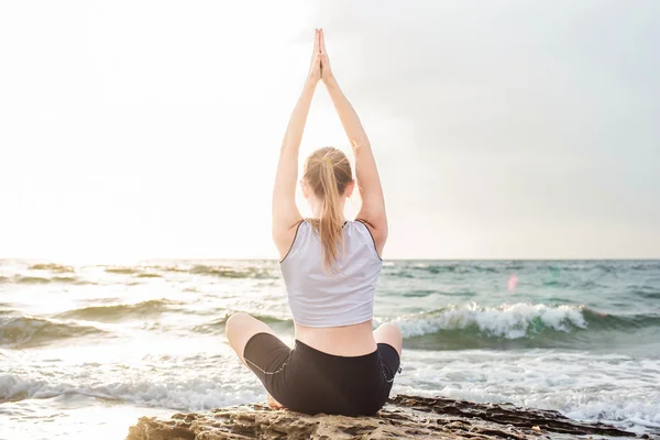 Fitness sport model  doing exercises during outdoor work out on sunrise. Beautiful caucasian female training outside on seaside in the morning