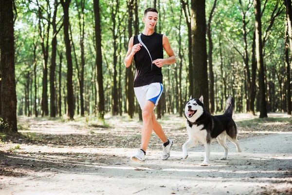 Work out with dog. Young caucasian male running with siberian hu