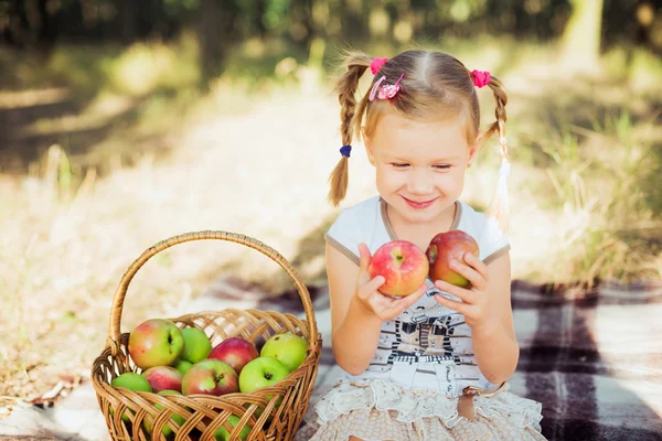 Little girl with apples in park