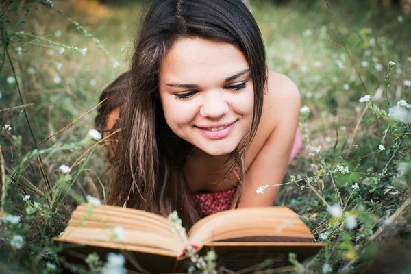 Young beautiful caucasian female reading book in park