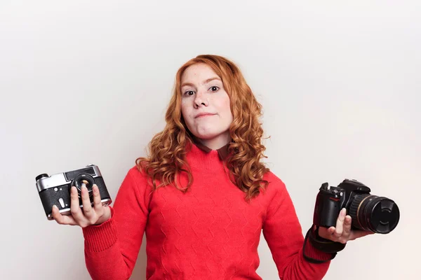 Woman holding vintage and modern cameras