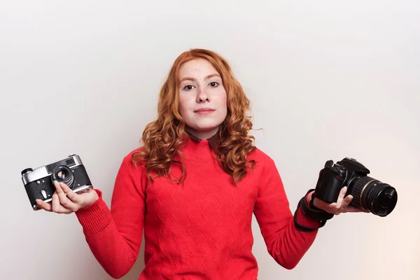 Woman holding vintage and modern cameras