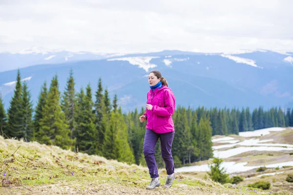 Female running athlete. Woman trail runner sprinting for success goals and healthy lifestyle in amazing nature landscape.