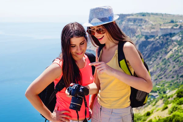Two young caucasian females making self portrait on a cliff above the sea