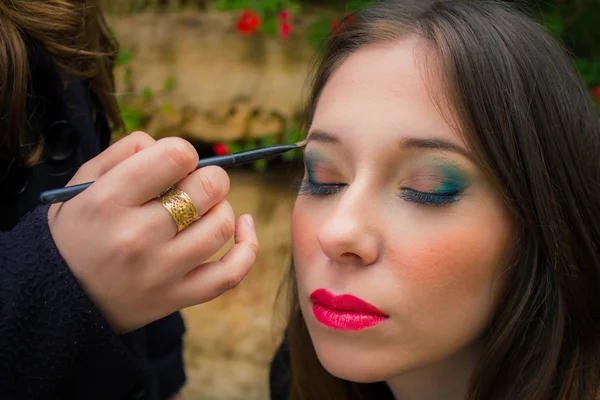 Professional make up artist doing glamour model makeup at work