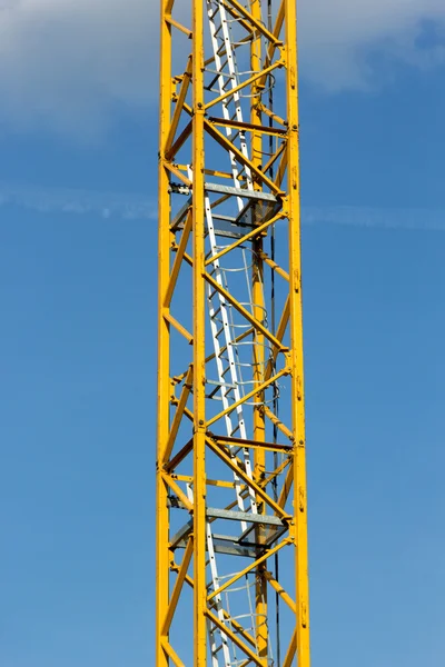 Ladder in the tower of yellow crane in blue sky