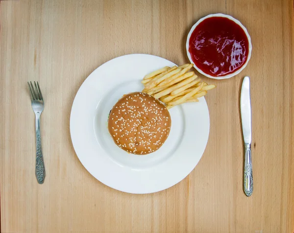 Fast food set big hamburger and french fries on wood background