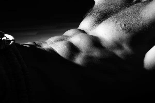 Naked man\'s chest in gym. Black and white photo.