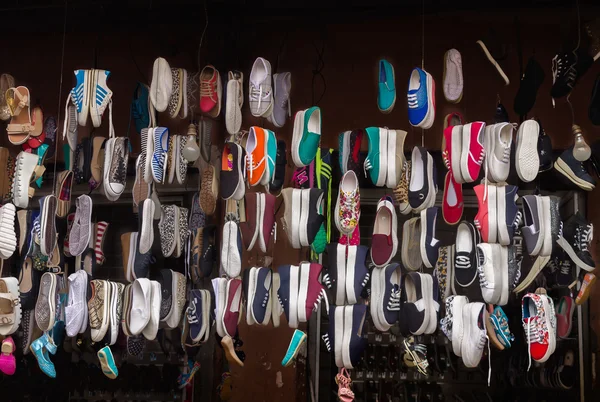 Lots of different shoes hanging in the showcase on market