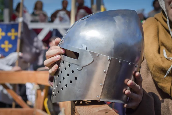 The man on the Knight Tournament holdind a knight\'s helmet