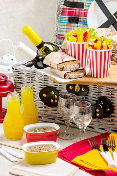 Table setting for a summer picnic. Picnic basket with food, wine