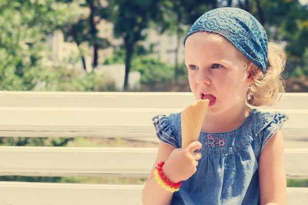 Funny little girl (3 years) eat ice cream.