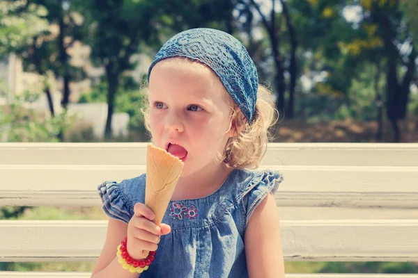 Funny little girl (3 years) eat ice cream.