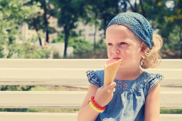 Funny little girl (3 years) eat ice cream.