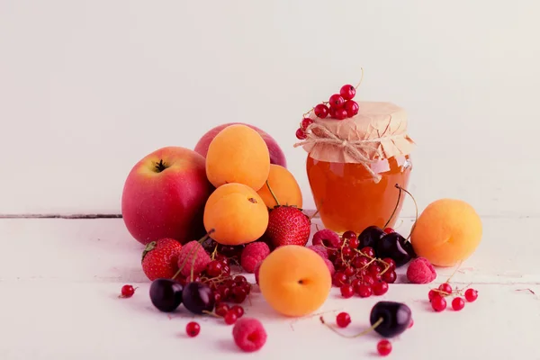 Apricot jam on a background of fruit and berries (apricots, appl