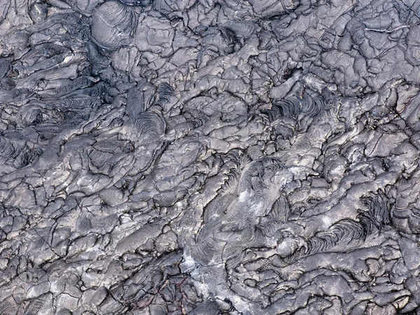 Patterns cracks and shapes from close up portion of black solidified lava, Hawaii