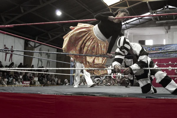 Male and female wrestlers in combat at the Cholitas Wrestling Event