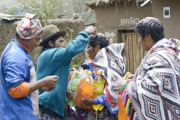 Traditional Quechua Wedding Ceremony. Indigenous woman putting confetti on the bride`s mother hair