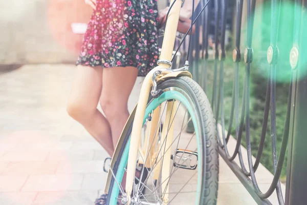 Closeup of woman riding by blue vintage city bicycle