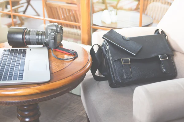 Laptop computer and dslr camera at cafe