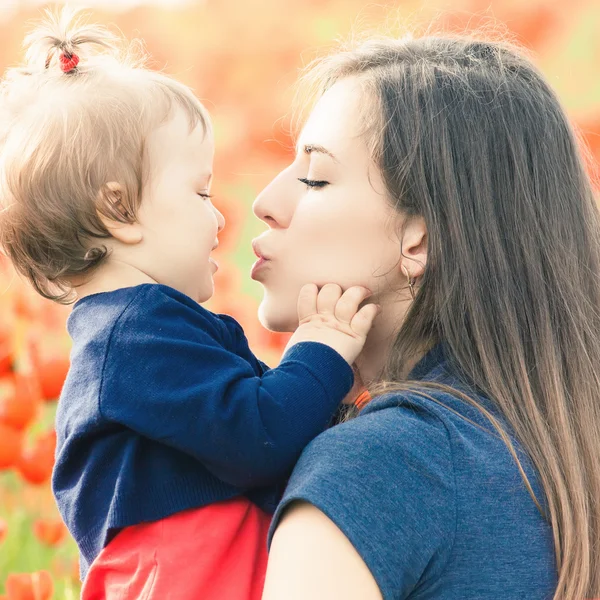 Mother with funny child outdoor at poppy flowers field