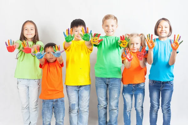 Happy kids with painted hands smiling