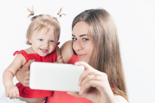 Funny baby and mother make selfie on mobile phone