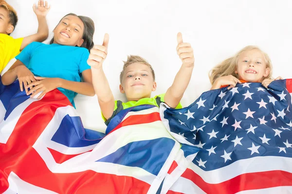 Funny kids holding flag Great Britain and american national flag