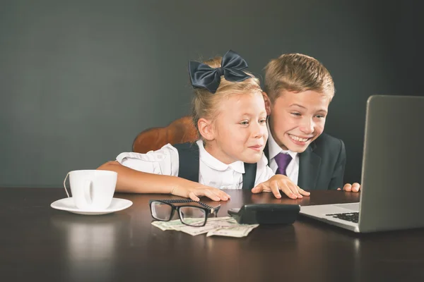 Business kids, children using laptop. Internet games