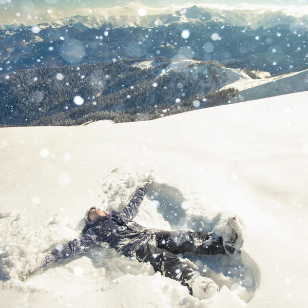 Happy woman making snow angel in the snow mountain. Ski.