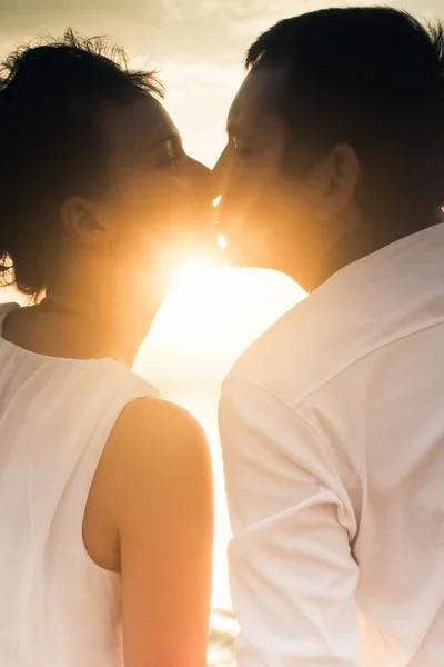 Kissing couple at sun background