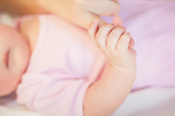 Mother holding baby feet at hands