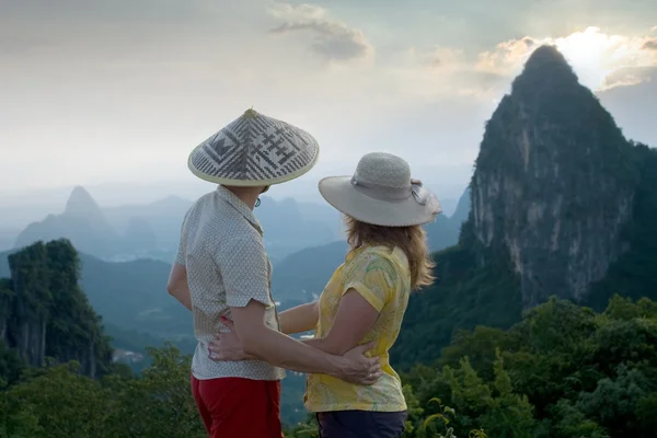 Portrait image of lovely couple at sunset on top of the Chinese mountain of Moon Hill