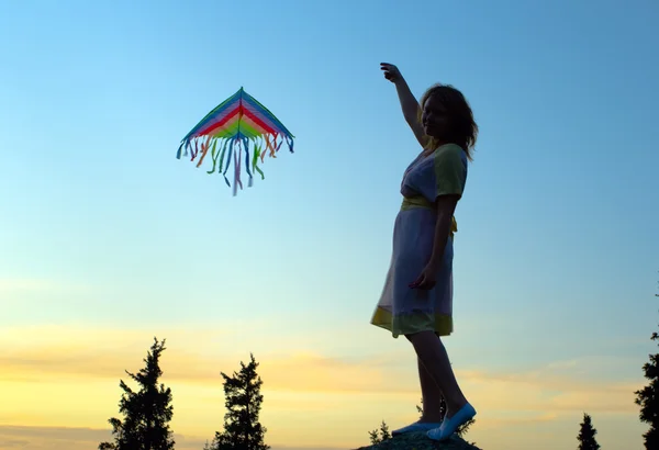 Young women flying a rainbow kite
