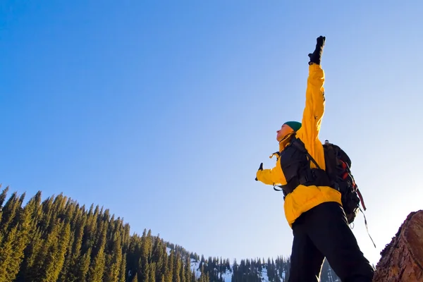 Climbing young adult at the top of summit