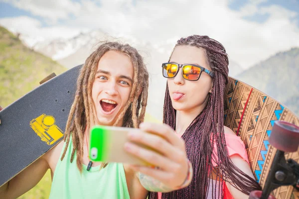 Happy people make selfie on mobile phone at mountain outdoor