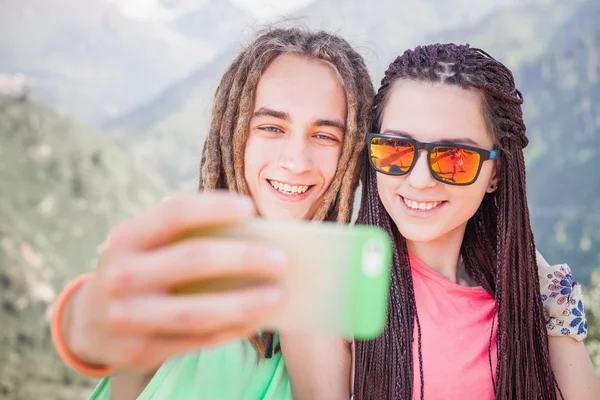 Happy people make selfie on mobile phone at mountain outdoor