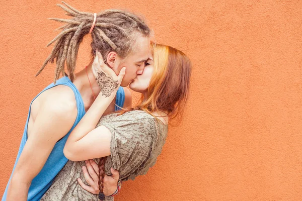 Happy and funny couple kissing at red wall background - Stock Image - Everypixel Happy and funny couple kissing at red wall background - Stock Image - Everypixel