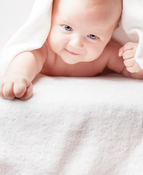 Happy baby after bathing, looks down on copy space