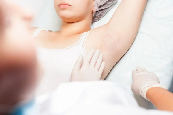 Professional woman at spa doing epilation armpits using sugar, sugaring