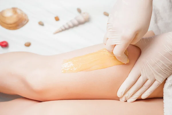 Sugaring epilation skin care with liquid sugar at legs