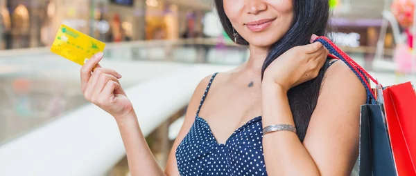 Close-up of asian woman\'s hand holding credit card and bags