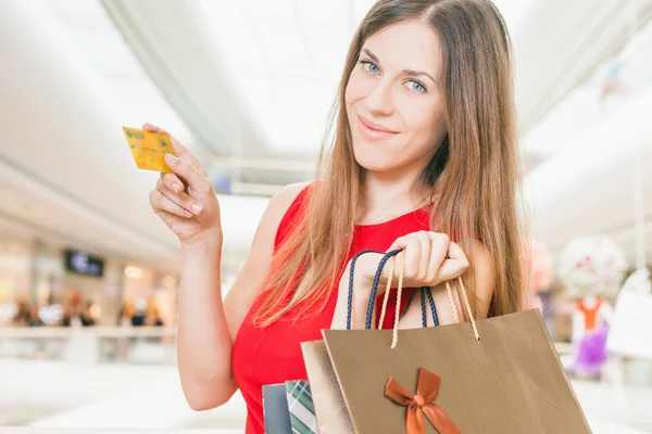 Fashion successful woman holding credit card and bags, shopping mall