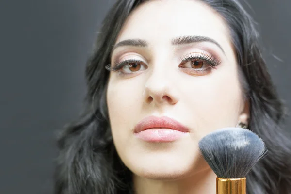 Beautiful woman at beauty salon receives makeup