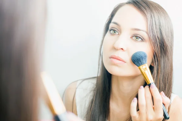 Makeup artist woman doing make-up using cosmetic brush for yourself