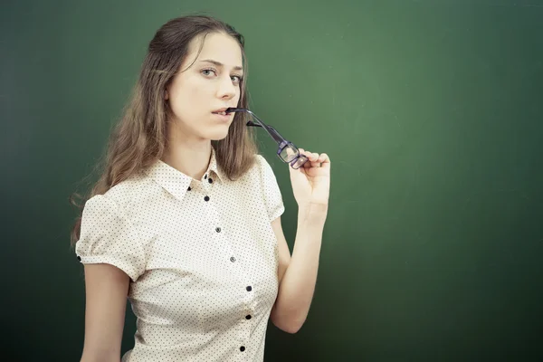 Pretty teacher or student holding glasses at classroom, university