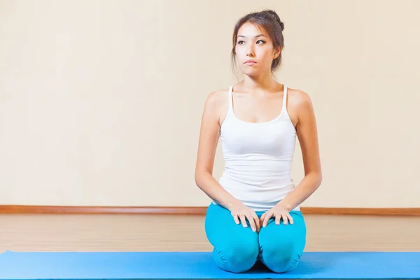 Inspired asian woman meditating before yoga exercise indoor